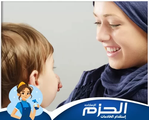 أفضل مربية أطفال في الشارقة لضمان رعاية مثالية مربية أطفال من شركة الحزم تحمل الطفل في حضنها بابتسامة دافئة
