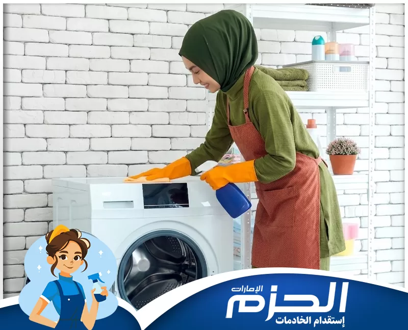 عاملات فلبينيات للتنازل في عجمان 0558713599 شركة الحزم عاملة تنظيف تنظف الغسالة من الخارج باستخدام بخاخ ومنشفة داخل غرفة غسيل منزلية مع شعار الحزم