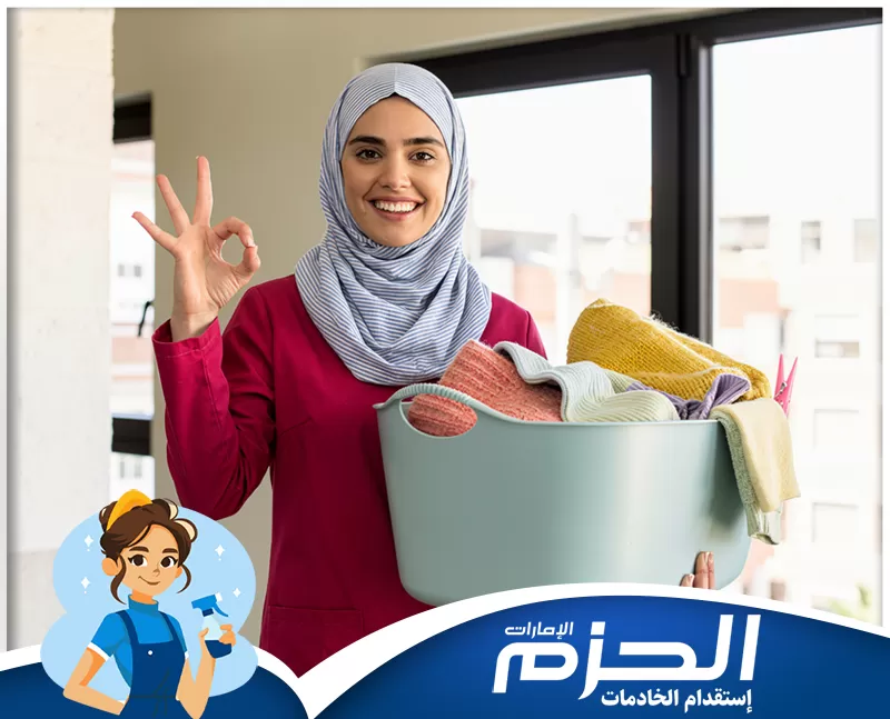 استقدام خادمات منازل الفجيرة للتواصل 0558713599 . عاملة منزلية تحمل سلة غسيل بملابس مرتبة، في صورة تعكس المساندة اليومية في أعمال المنزل وتنظيم المهام بطريقة تساعد على استقرار البيت وتخفيف الأعباء المتكررة.